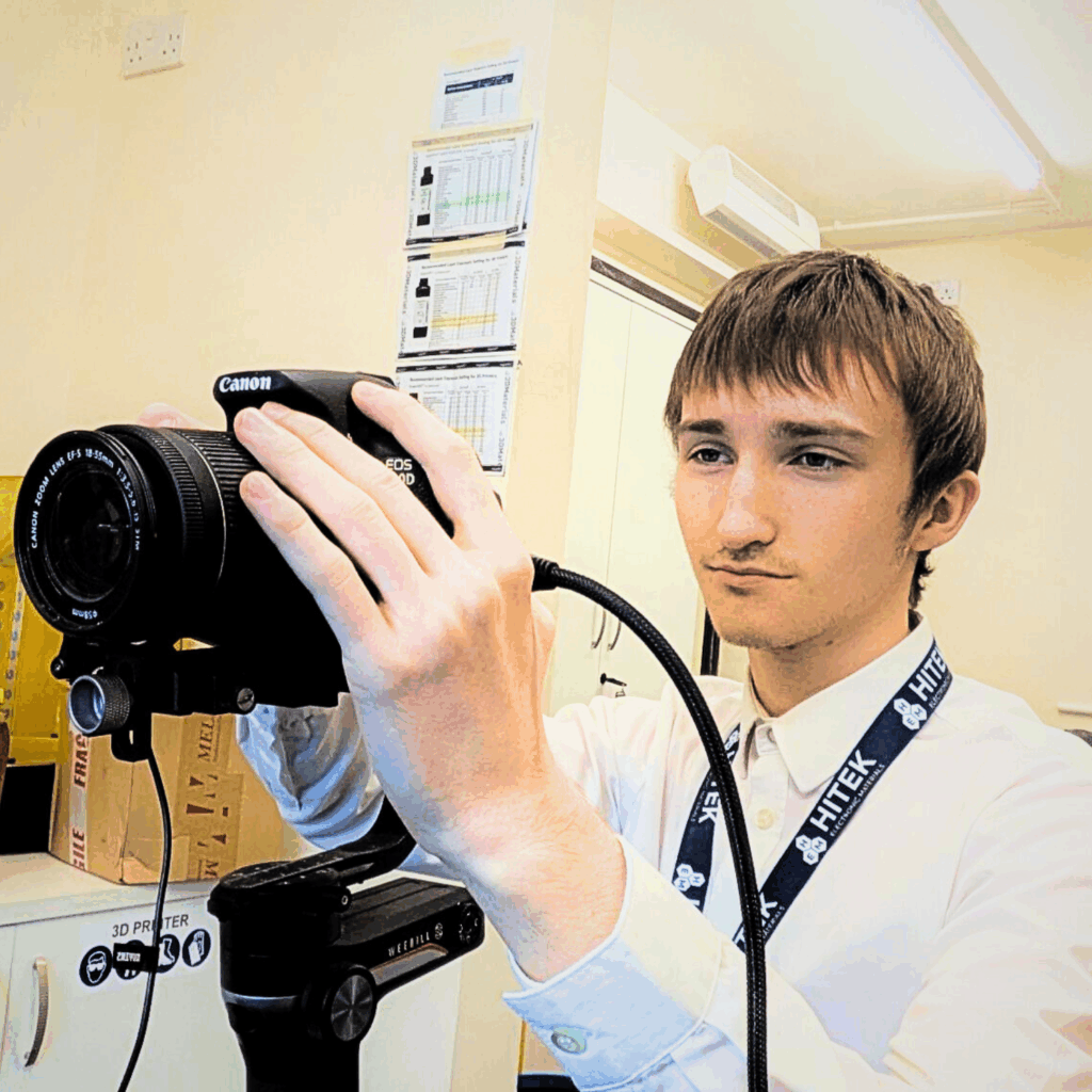 Lennon holding a camera, ready to take a photo.