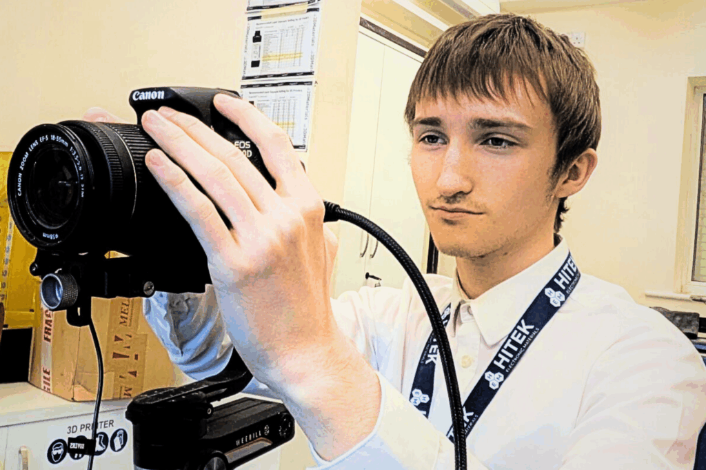Lennon holding a camera, ready to take a photo.
